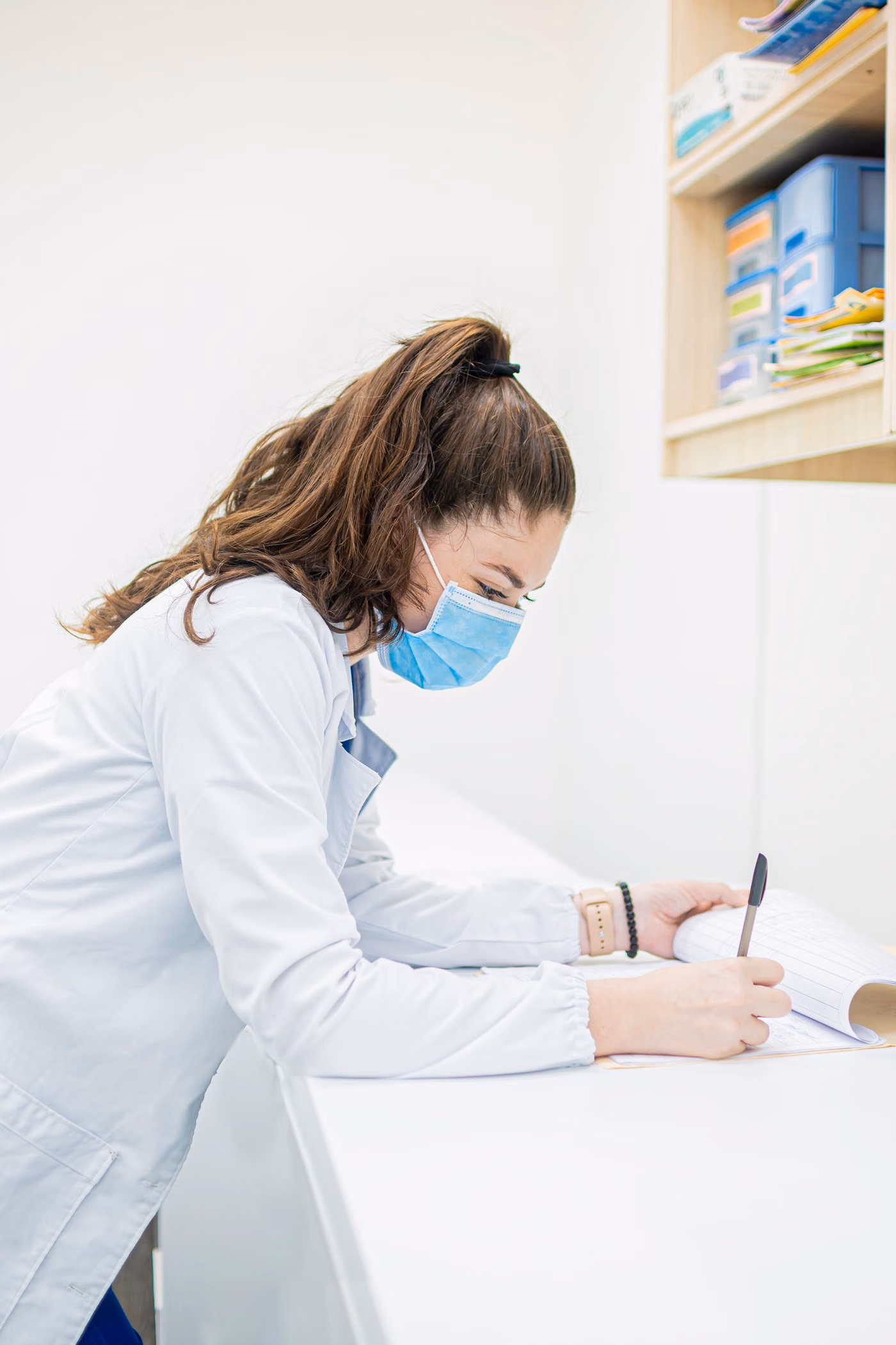 Medical worker writing on documents in a workplace