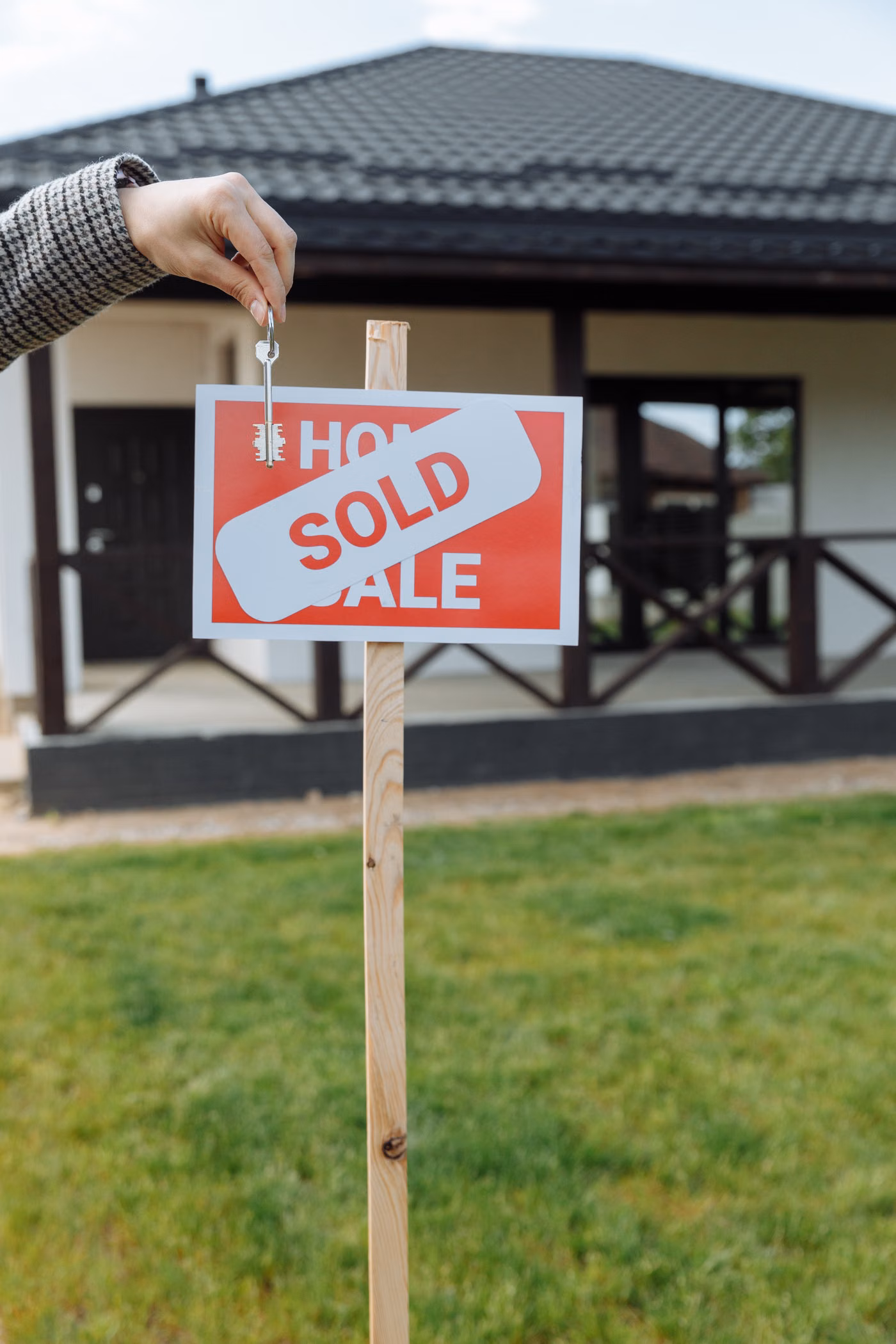 Person holding a house key during a home purchase